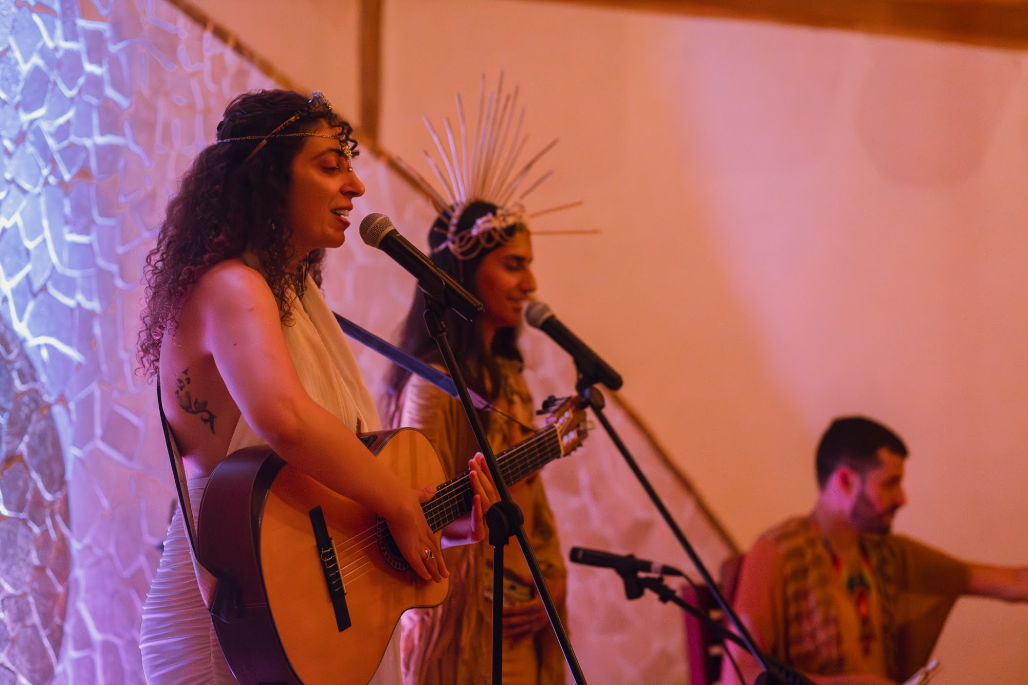 Two musicians singing and playing guitar at a gathering at Awake.