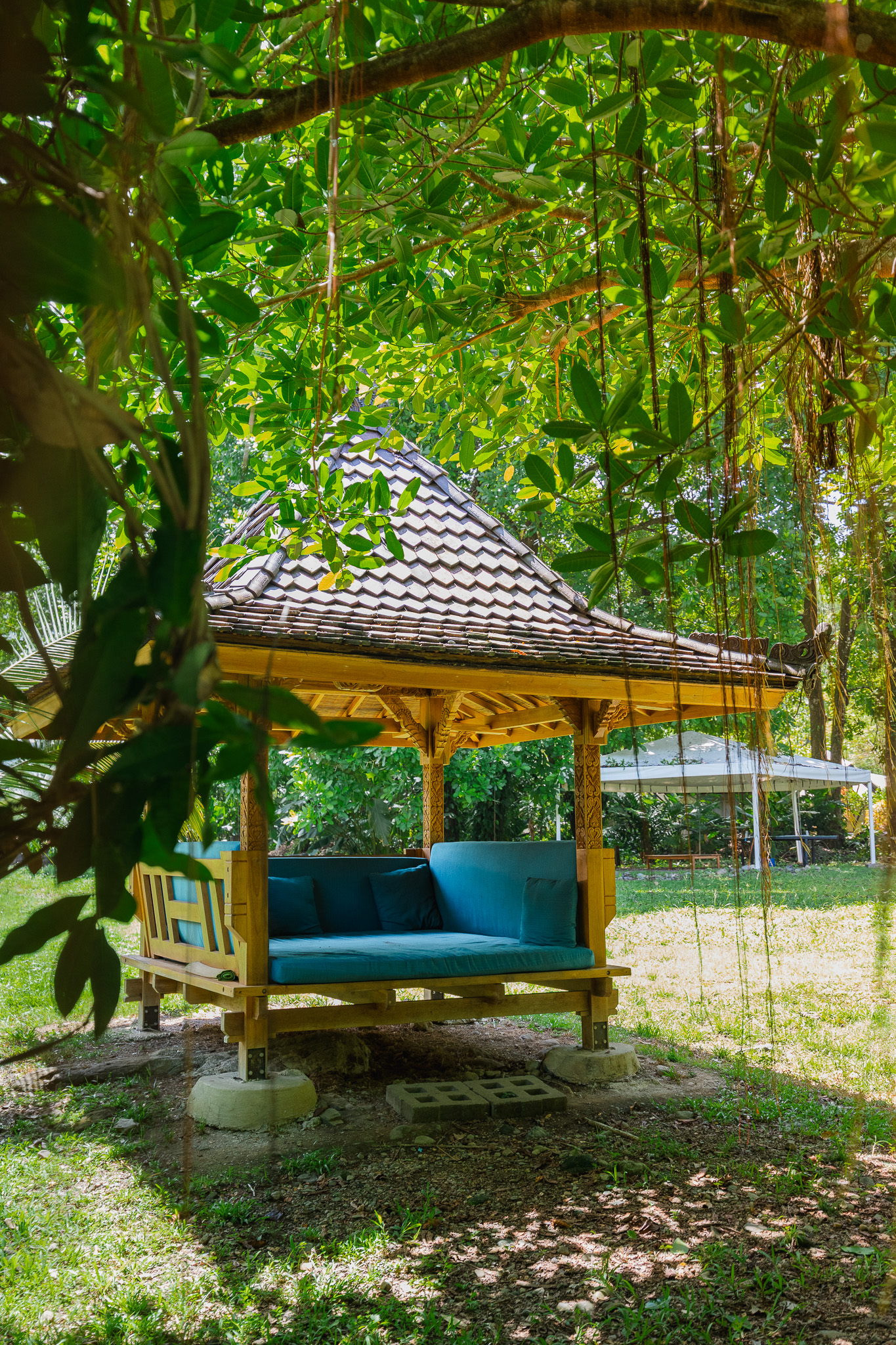 A carved wooden gazebo daybed resting in the Awake garden